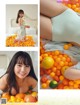 A woman laying on top of a bed covered in oranges.