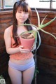 A young woman holding a potted plant in her hands.