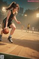 A woman in a basketball uniform dribbling a basketball on a court.