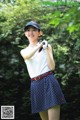 A woman in a polka dot skirt holding a golf club.