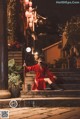 A woman in a red dress sitting on some steps.